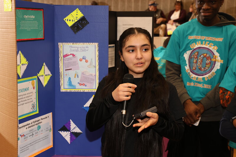 Student presenting her scientific method project to judges