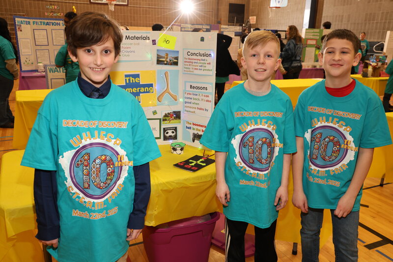 Three students presenting their boomerang ball project